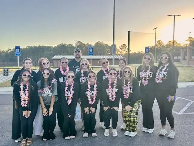 Richmond Hill Lady Wildcats softball players and their coach in team sweatshirts, leis and pink sunglasses before leaving for the GHSA state tournament in Columbus